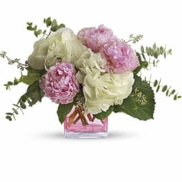 Pink and white peony bouquet in a pink glass vase