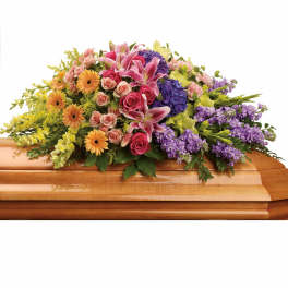 Colorful floral casket spray with lilies, roses, and gerbera daisies
