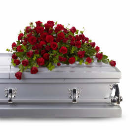 Red rose and carnation casket spray on a silver casket