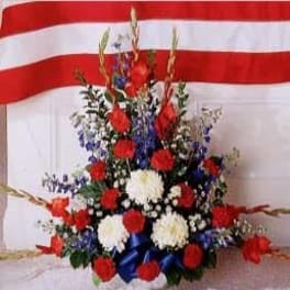 Red, white, and blue floral arrangement with ribbon accents