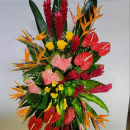 Tall tropical floral standing arrangement with red, orange, and pink blooms