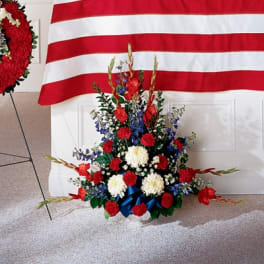 Red, white, and blue funeral spray with carnations and gladiolus