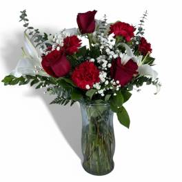 Red roses and carnations with white lilies in a glass vase