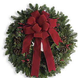 Christmas wreath with a red bow, pinecones, and red berries