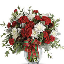 Red and white flowers arranged in a clear glass vase with a plaid ribbon
