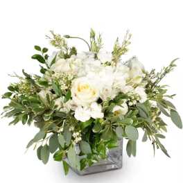 White rose arrangement in a square glass vase with mixed greenery