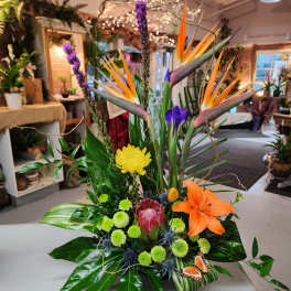 Tropical floral arrangement with orange bird-of-paradise and purple accents