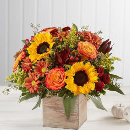 Autumn bouquet with sunflowers, roses, and mums in a wooden box