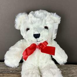 White plush teddy bear with a red ribbon bow