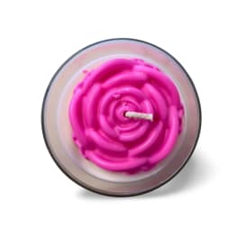 Pink rose-shaped candle in a glass container