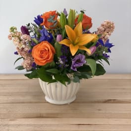 Colorful bouquet of roses and lilies in a white vase