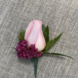 Pink rose boutonniere with small purple accent flowers