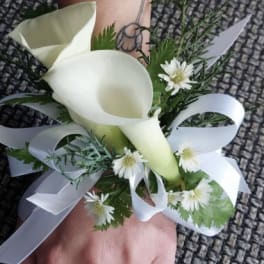 White calla lily wrist corsage with small white daisies and ribbon
