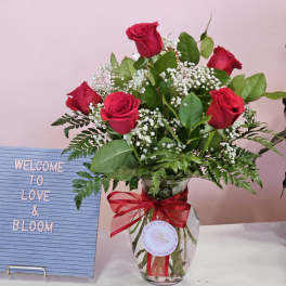 Red roses in a glass vase with a red ribbon