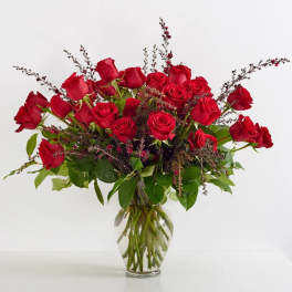 Red roses arranged in a clear glass vase