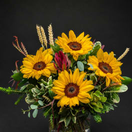 Bouquet of yellow sunflowers in a clear glass vase