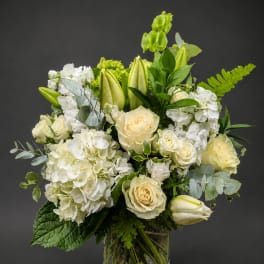 White and cream floral arrangement in a clear glass vase