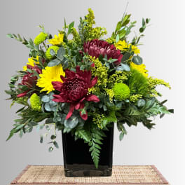 Bouquet of burgundy and yellow chrysanthemums in a black vase