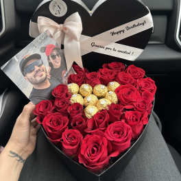 Heart-shaped box of red roses with gold chocolates and a photo card