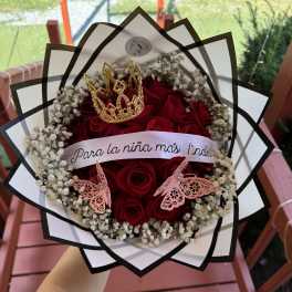 Red roses arranged with baby's breath in a decorative bouquet wrap