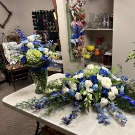 Blue and white floral arrangements in glass vases on a table