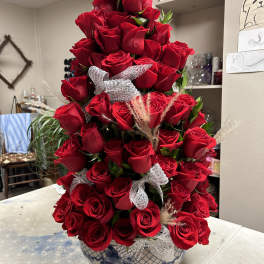 Tall arrangement of red roses in a blue-and-white ceramic vase