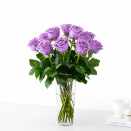 Lavender roses arranged in a clear glass vase