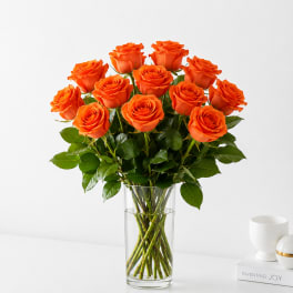 Orange roses arranged in a clear glass vase