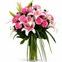 Pink roses and white lilies arranged in a clear glass vase