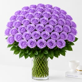 Large bouquet of lavender roses in a clear glass vase