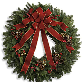 Christmas wreath with a red bow, pinecones, and red berries