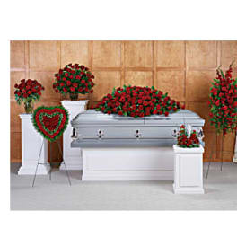 Funeral casket surrounded by red rose sprays and wreaths