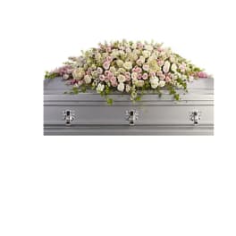 Large pink and white floral casket spray on a silver casket