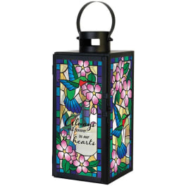 Decorative black lantern with stained-glass floral panels and a memorial message