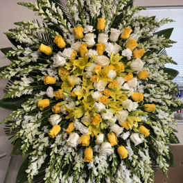 Large yellow and white floral standing spray with roses and lilies