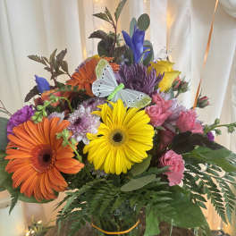 Colorful mixed bouquet in a glass vase with a butterfly decoration