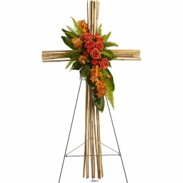 Orange floral cross on a stand with roses and orchids
