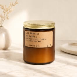 Amber soy candle in a glass jar with a gold lid