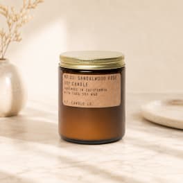 Amber jar candle with a gold lid and kraft label