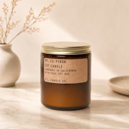 Amber soy candle in a glass jar with a metal lid