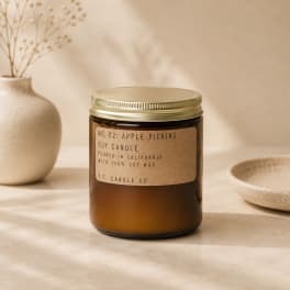 Amber jar candle with a gold lid and paper label