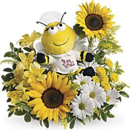 Bee plush surrounded by sunflowers and daisies