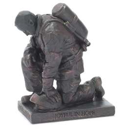Bronze-toned kneeling firefighter statue on a rectangular base