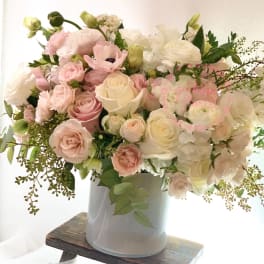Blush and white rose bouquet in a white vase