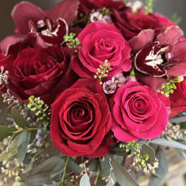 Bouquet of red roses and burgundy orchids with eucalyptus