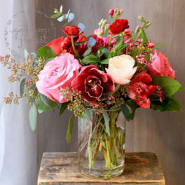 Bouquet of pink and red flowers in a clear glass vase