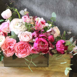 Pink and white roses arranged in a wooden box