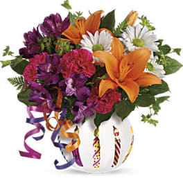 Bouquet of orange lilies, purple flowers, and white daisies in a decorated vase