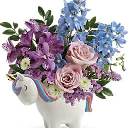 Bouquet of pink and blue flowers in a unicorn-shaped vase