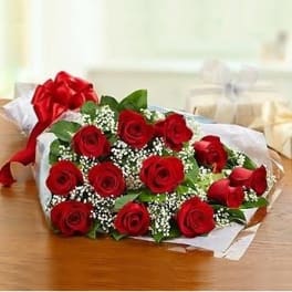 Bouquet of red roses wrapped in white paper